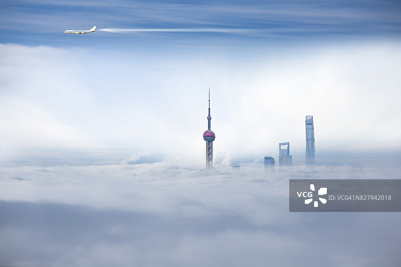 飞机飞过上海市景，陆家嘴商业楼在雾中图片素材