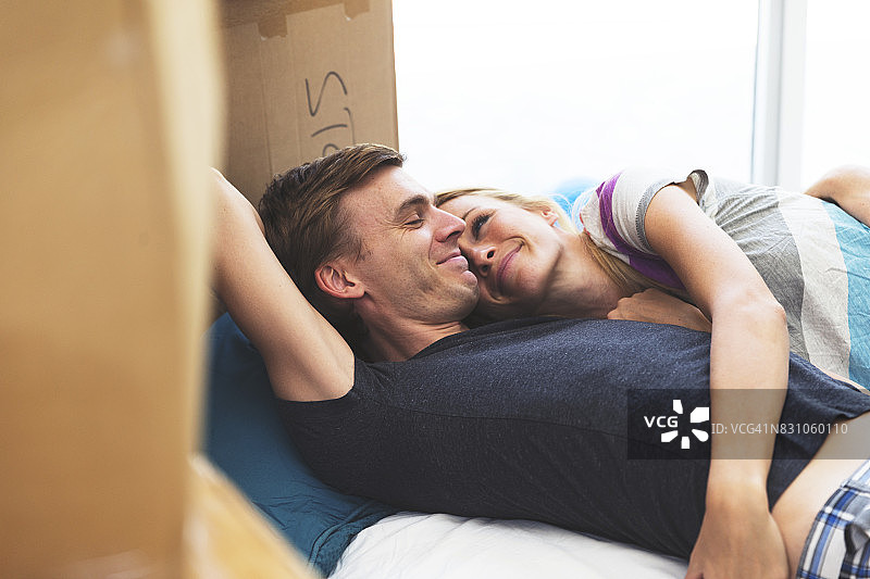一对夫妇在新家地板上的一张临时床上醒来图片素材
