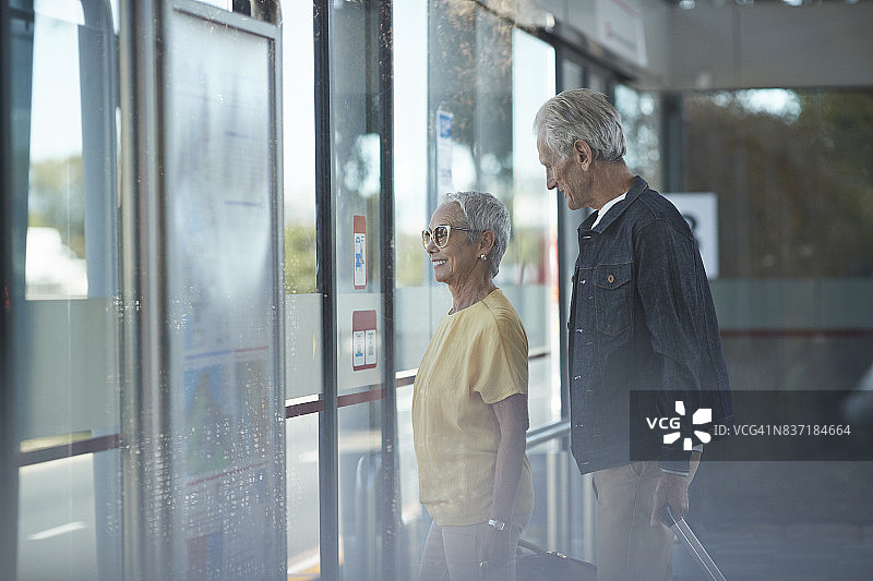 一对老年夫妇在公交车站等车图片素材