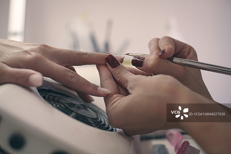 女性的手被修剪在美容院的特写。图片素材