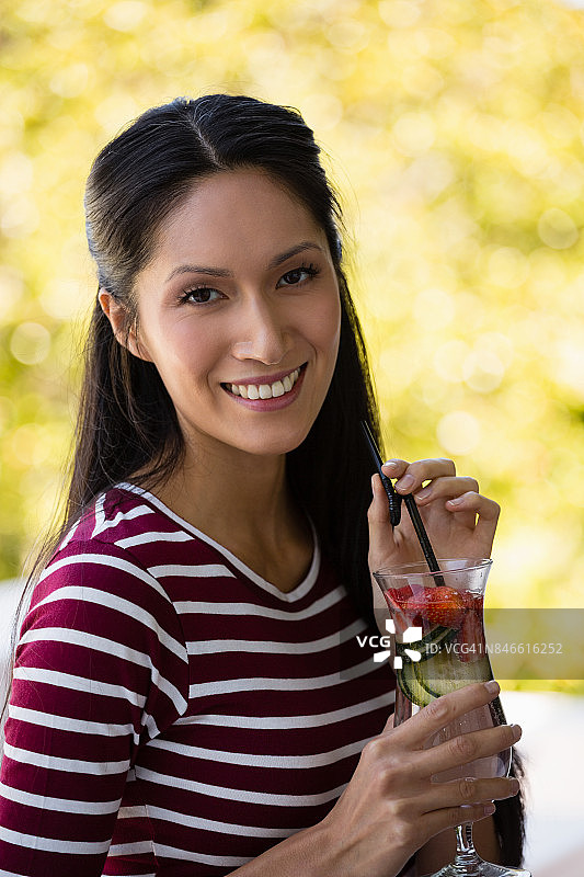 年轻女子拿着鸡尾酒的肖像图片素材