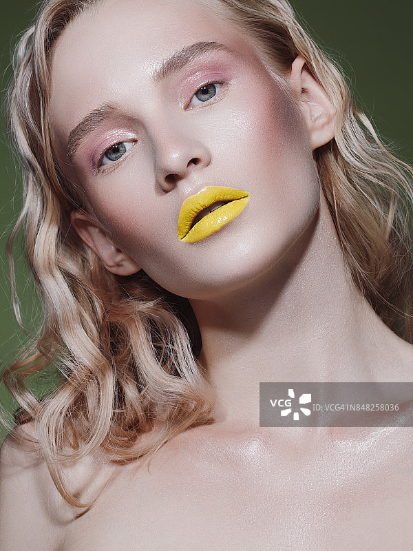 年轻漂亮的女人，涂着黄色唇膏图片素材