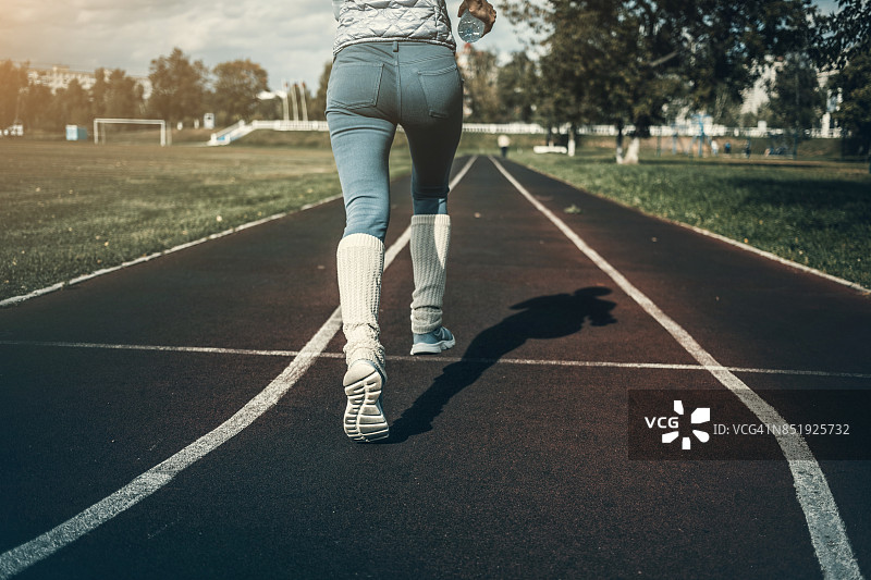 在体育场跑道上跑步的女人图片素材