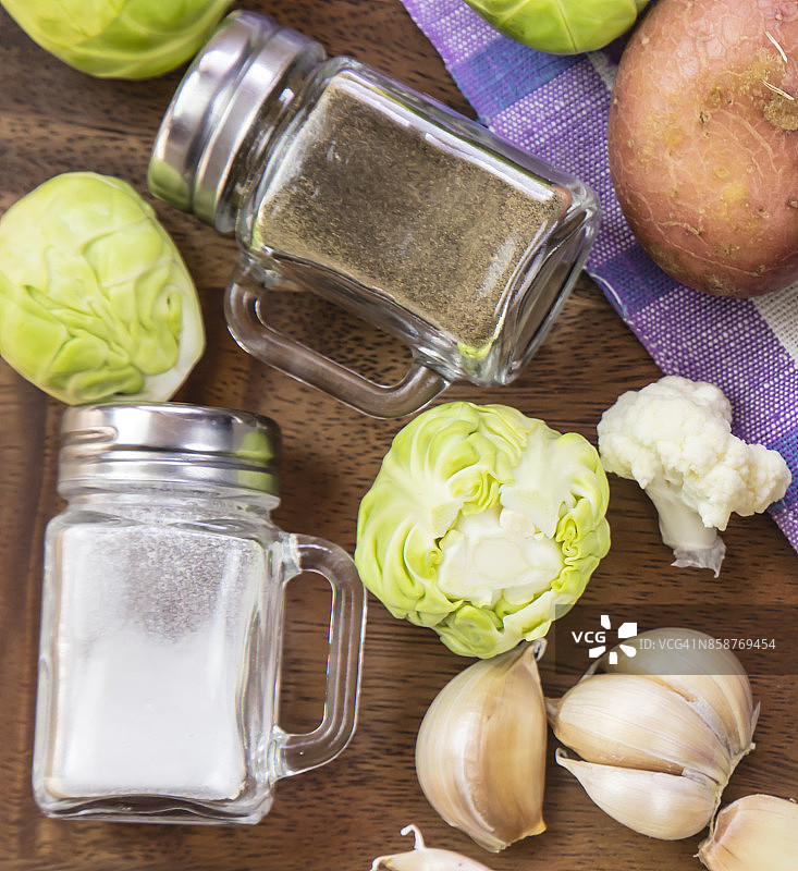 盐和胡椒瓶和蔬菜-花椰菜，球芽甘蓝，土豆图片素材