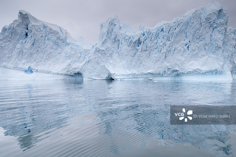 一座巨大的冰山从冰川崩解下来。展示了美丽的蓝色冰图片素材