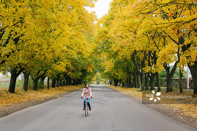 秋天里骑自行车的女人图片素材
