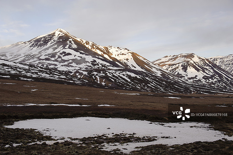 冰岛东峡湾博加尔峡湾(Borgarfjordur)的雪山和农场图片素材