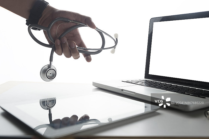 选择性聚焦笔记本电脑与手持听诊器和医生工作平板电脑在医院，医疗保健和医疗概念图片素材
