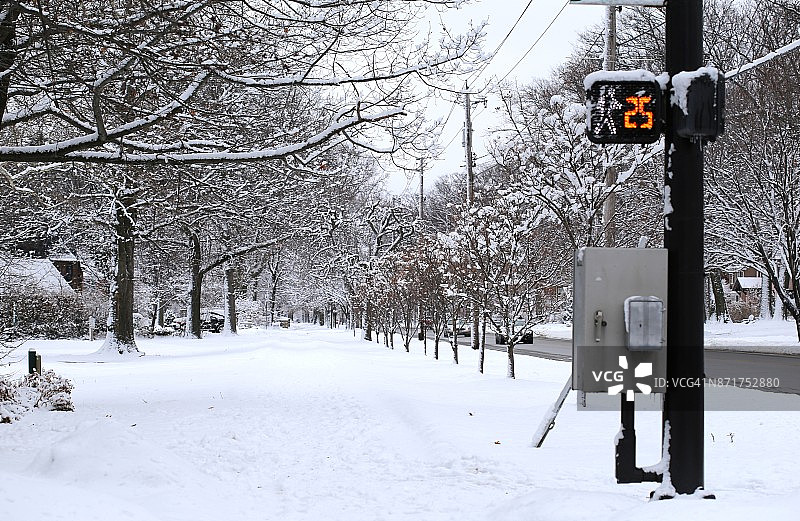 积雪覆盖的城市人行道上有人行横道标志图片素材