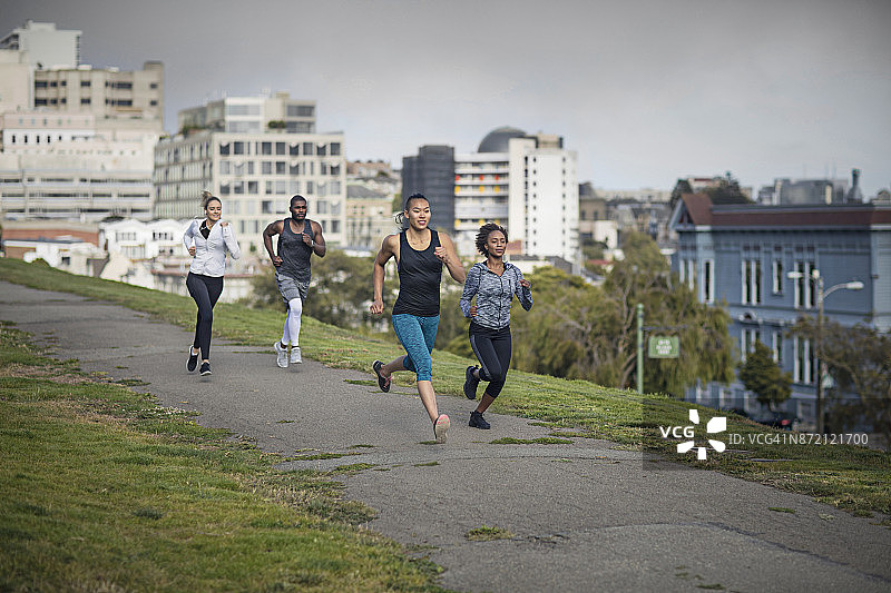 四个不同种族的人在美国加州旧金山的一个公园里跑步图片素材