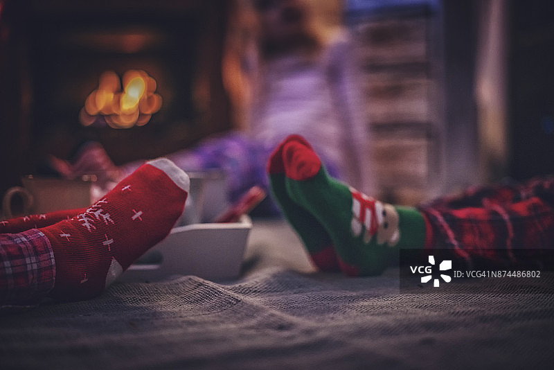 穿着睡衣和圣诞袜的可爱小孩坐在壁炉前图片素材