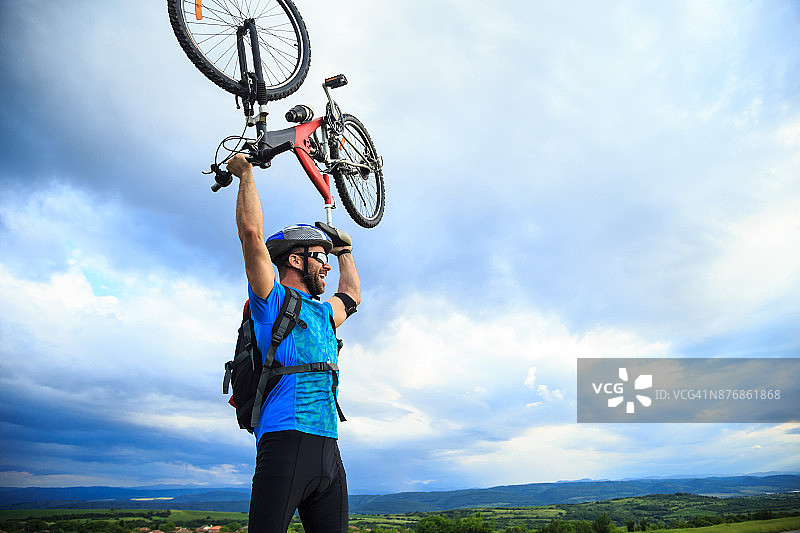 快乐的自行车手举起他的自行车图片素材