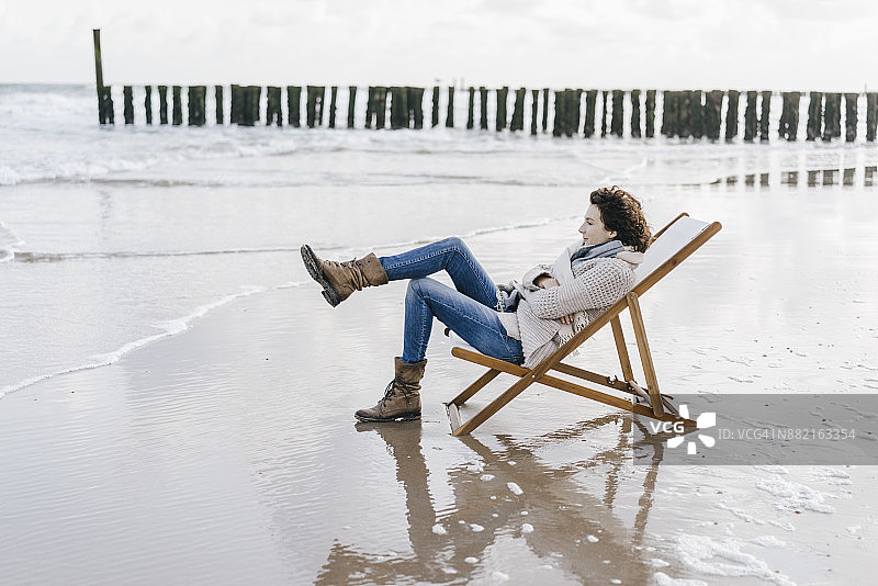 坐在沙滩躺椅上的女人图片素材