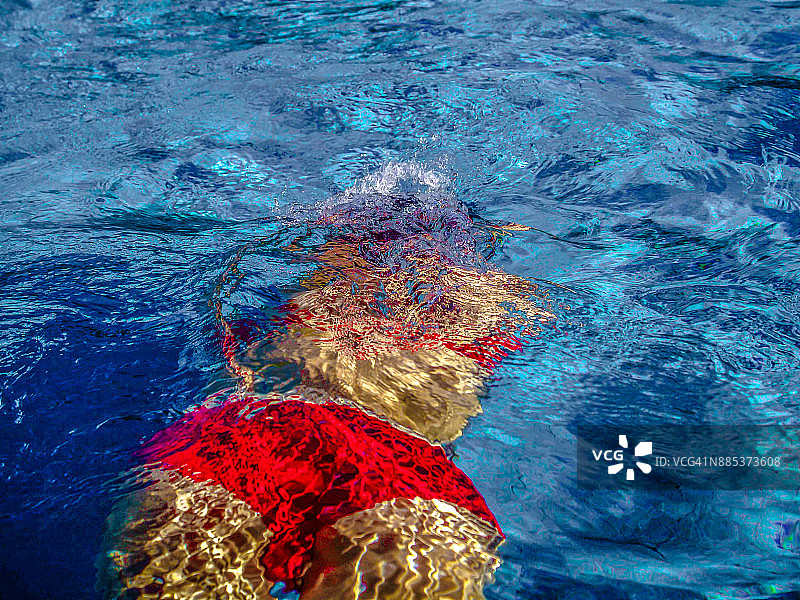 穿着红色潜水衣的女人在蓝色的水池里图片素材