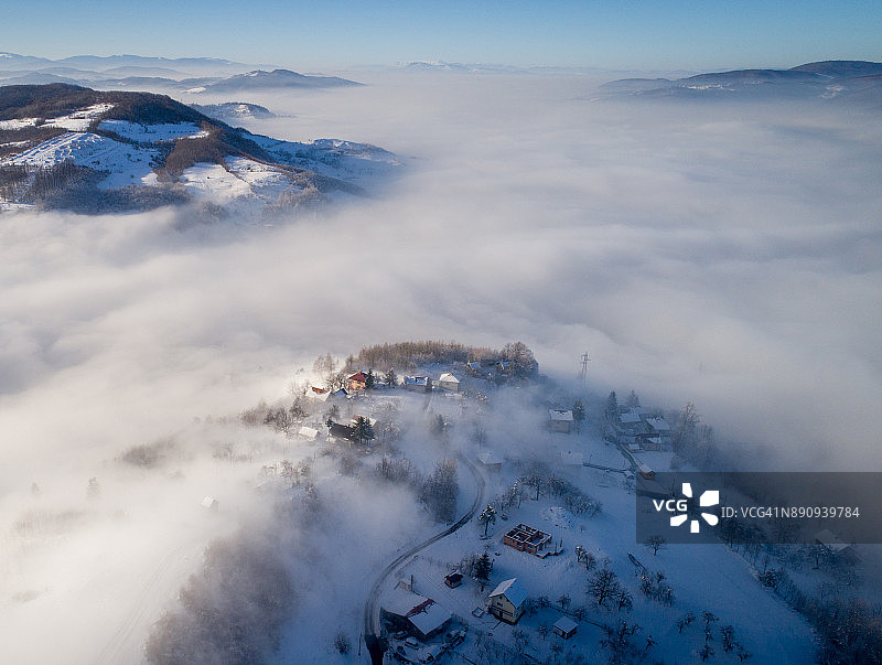 无人机拍摄的冬季雾气弥漫的雪村图片素材