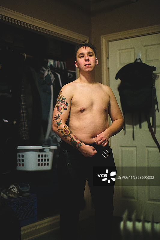 纹身男子在卧室生活方式照片穿衣服图片素材