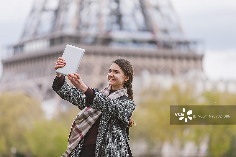 法国巴黎，一名年轻女子正在用平板电脑聊天图片素材