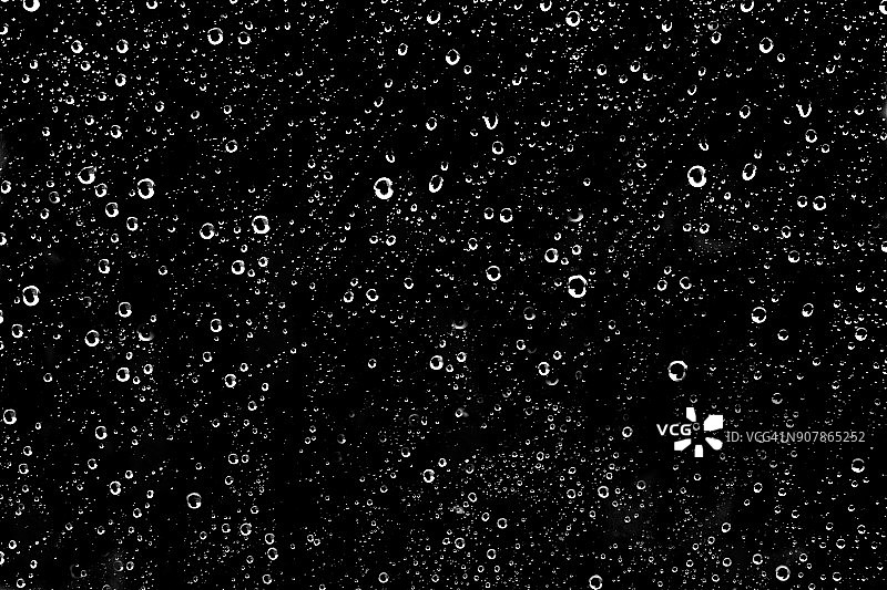 成百上千的白色雨滴落在玻璃窗上图片素材