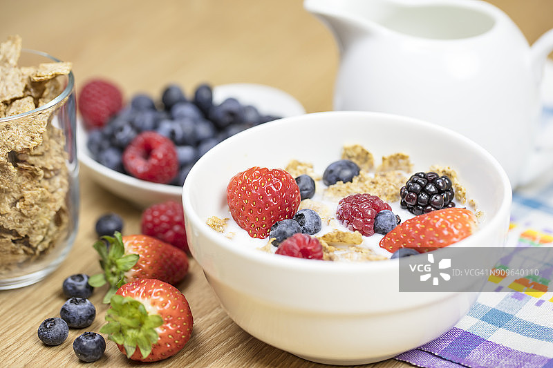自制格兰诺拉麦片或麦片粥，燕麦片，玉米片，干果和新鲜浆果在碗里。健康的早餐图片素材
