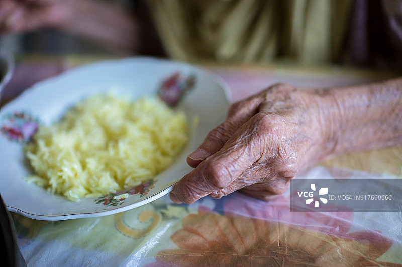很老的穆斯林妇女在家吃午饭图片素材