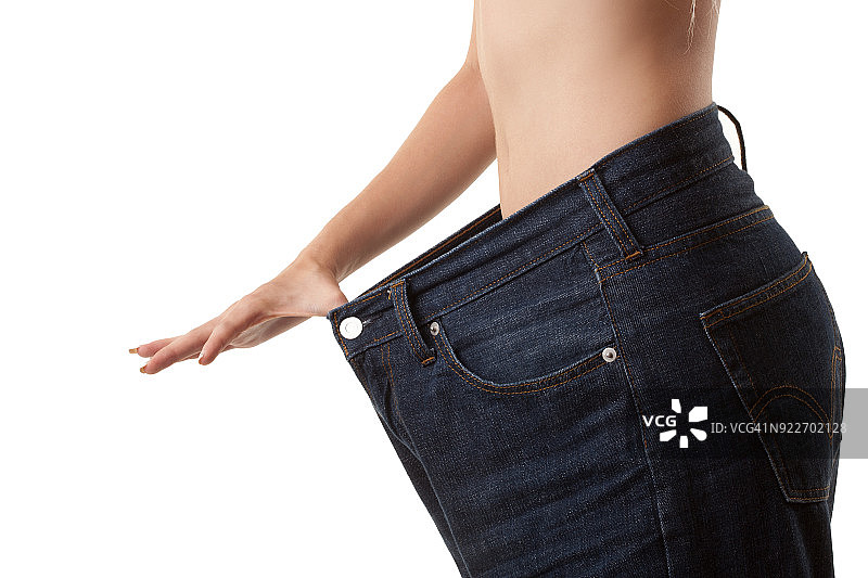 女人拿着打开的牛仔裤代表减肥量图片素材