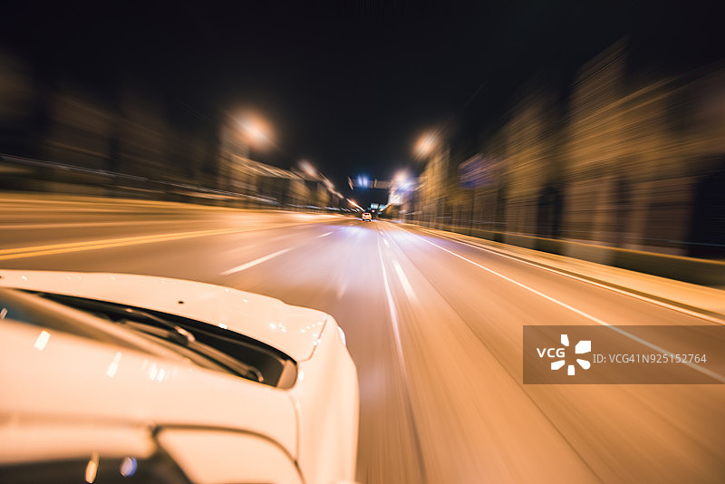 运动模糊拍摄的汽车行驶在夜晚的低谷镇图片素材