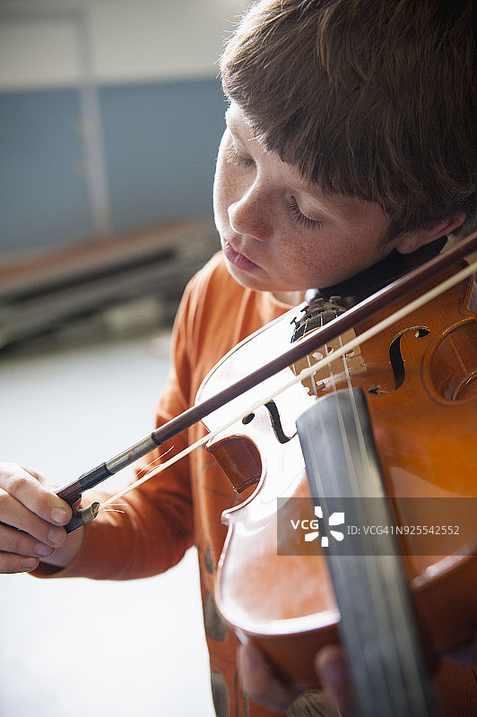 白人男孩练习小提琴的特写图片素材