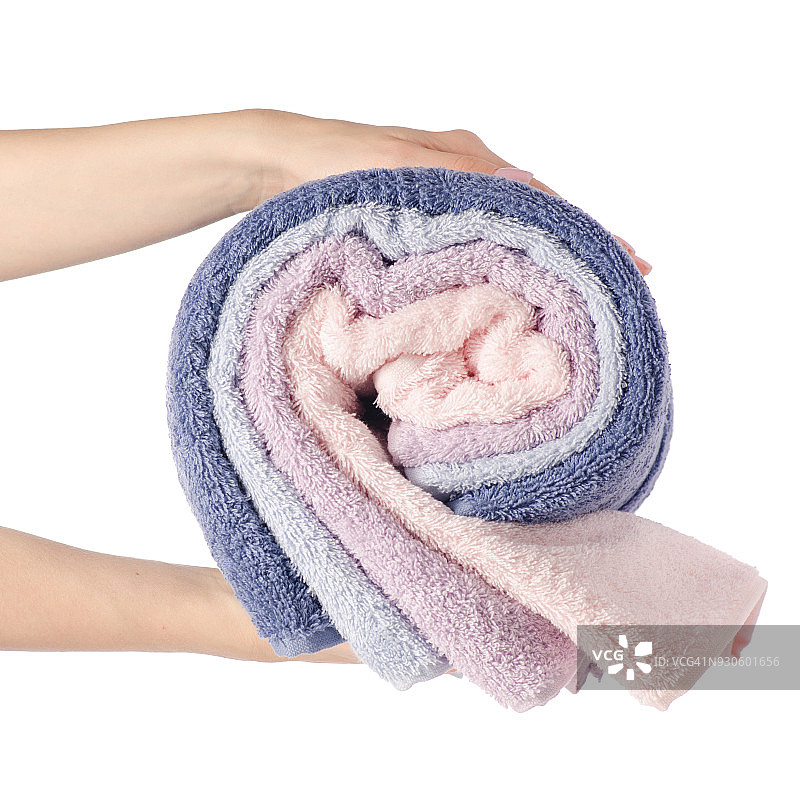 一叠粉蓝色的毛巾卷在手里图片素材