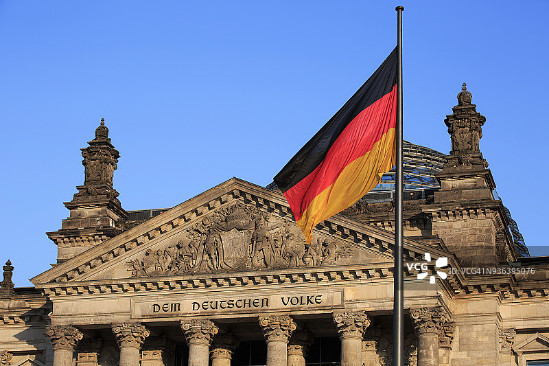 柏林国会大厦西门的镶边刻有著名的铭文:“德国人民”，带有德国国旗(德国)。图片素材