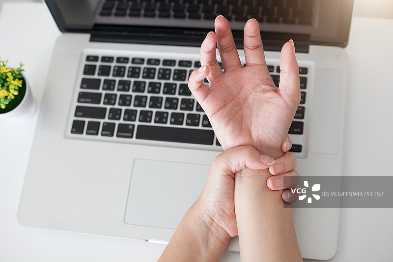 一位女士因使用电脑而手腕疼痛。,手痛图片素材