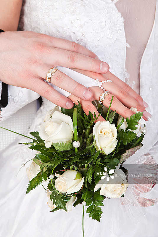 新娘和新郎的手拿着戒指和婚礼花束图片素材