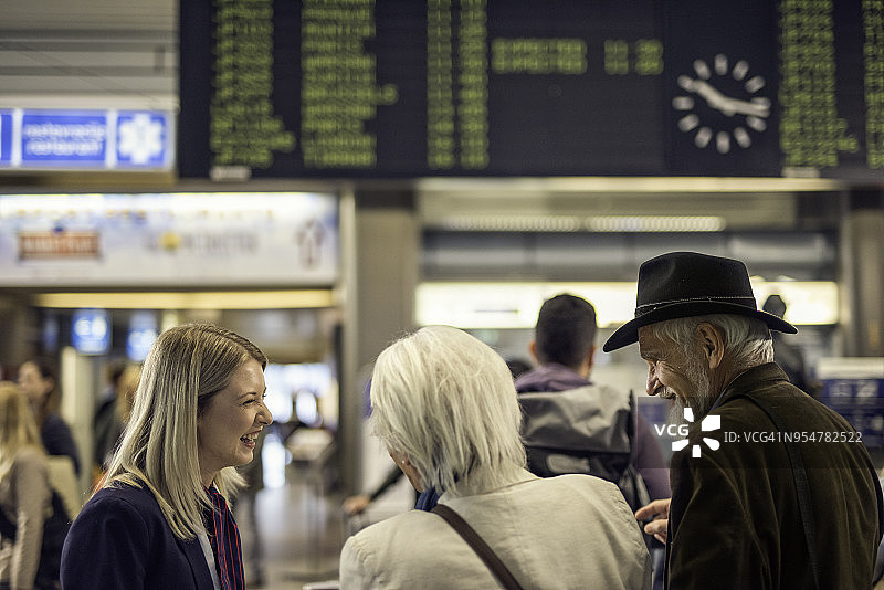 微笑的机场服务员帮助老夫妇图片素材