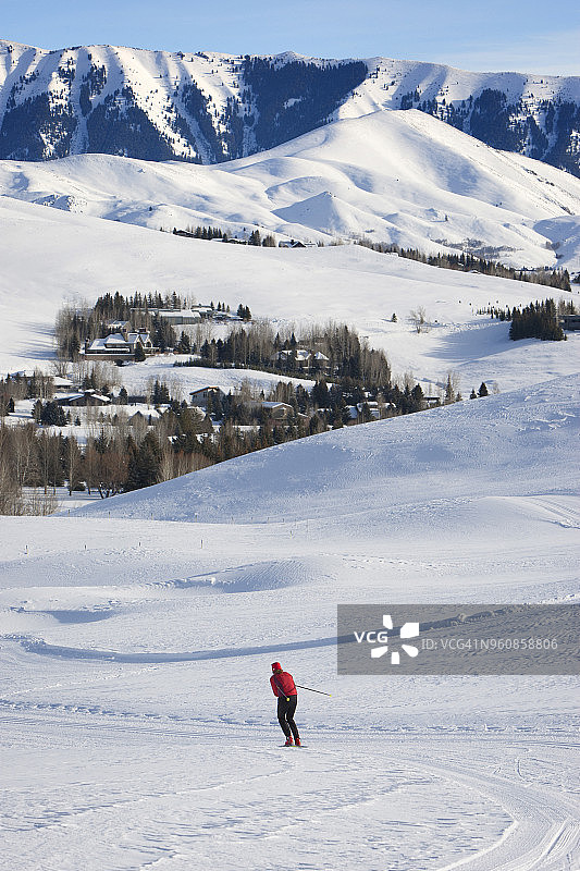 远处的女人在雪地上滑雪图片素材