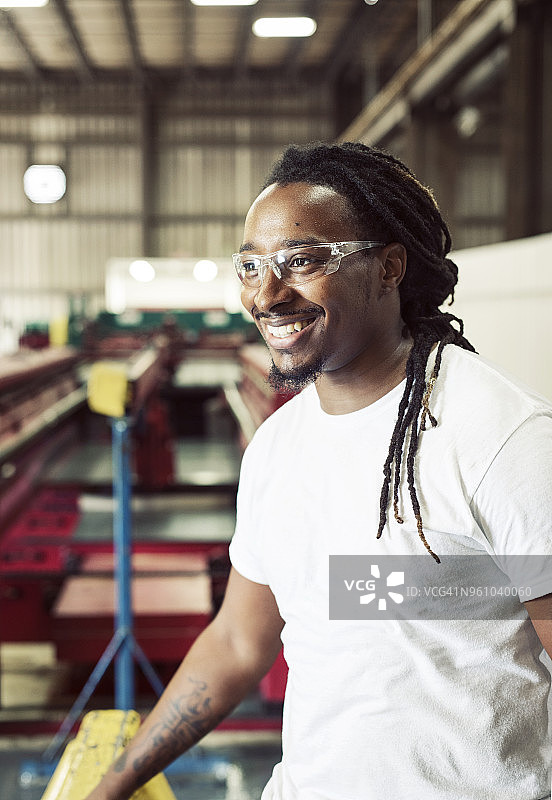 笑容可掬的蓝领工人戴着防护眼镜在钢铁行业工作图片素材