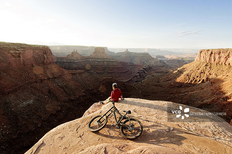 高角度的山地车与自行车坐在悬崖上对天空图片素材