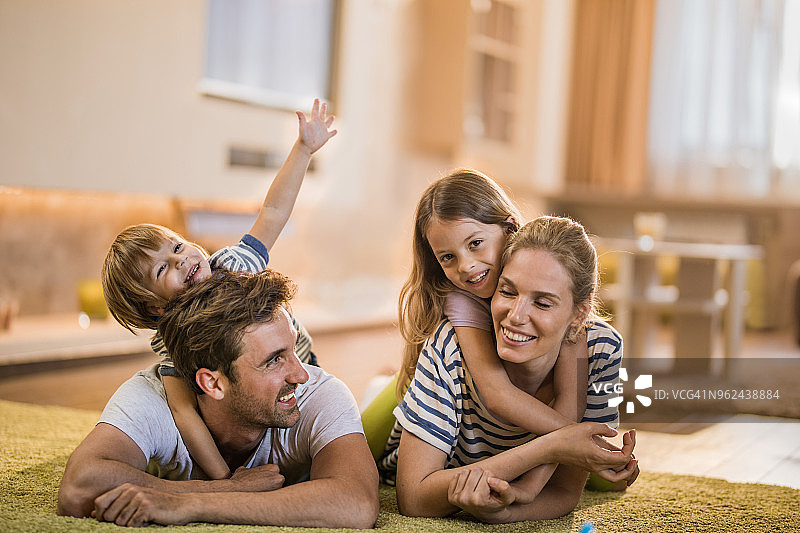 年轻幸福的家庭在客厅一起享受他们的时光。图片素材