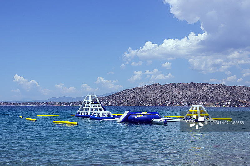 充气水上滑梯在海上。希腊。概念-旅游，海边度假。图片素材