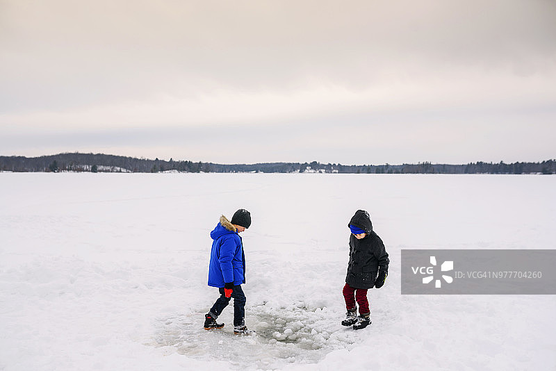 两个男孩在结冰的湖面上玩耍图片素材