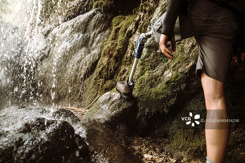 一个残疾人在瀑布旁徒步旅行图片素材