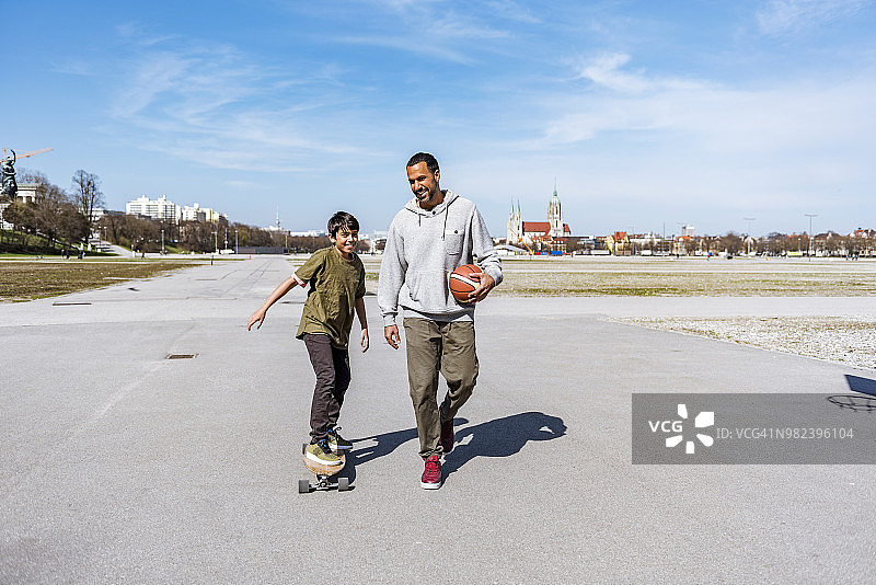 父亲和儿子带着长板和篮球在户外图片素材