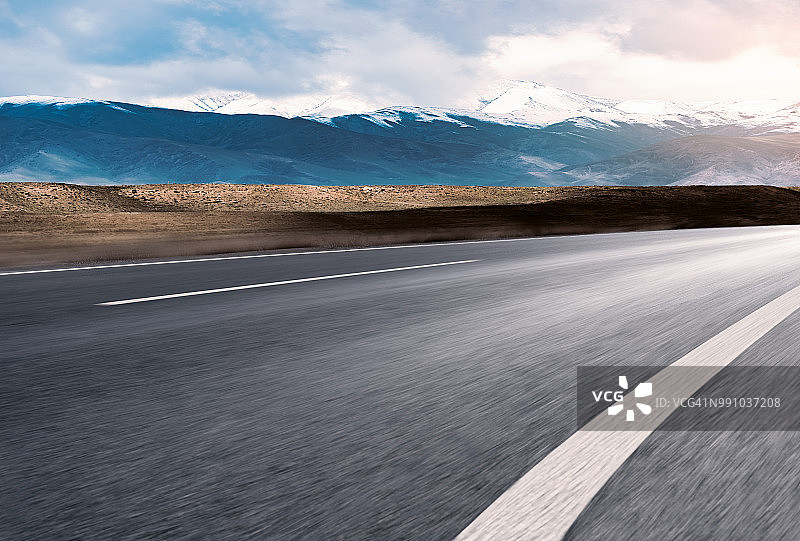 空旷的道路通向白雪覆盖的山脉图片素材
