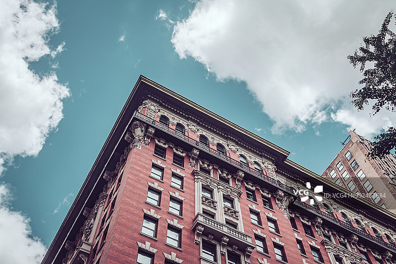 在曼哈顿市中心的蓝天映衬下，历史悠久的住宅建筑图片素材