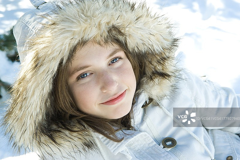 十几岁的女孩在雪中穿着皮大衣，肖像图片素材