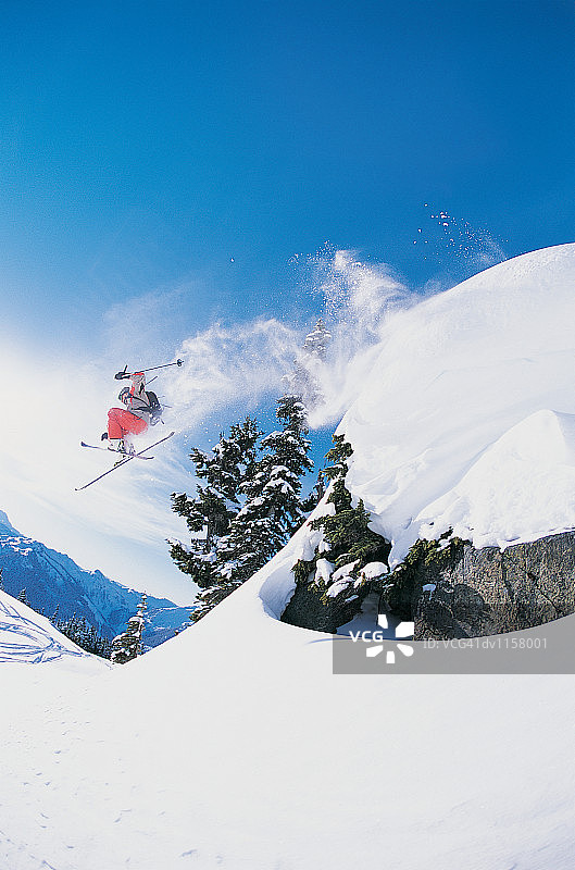 滑雪者在半空中跳过陡峭的斜坡图片素材