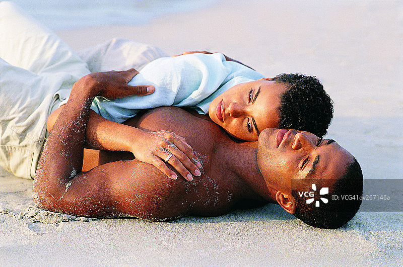 一对夫妇躺在沙滩上图片素材