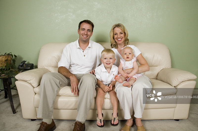 家庭照片，女儿(9个月)和儿子(4年)在沙发上图片素材