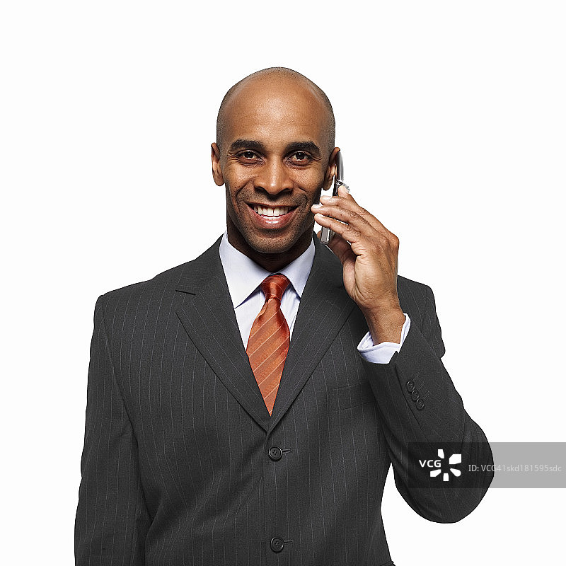 一个微笑的商人用手机聊天的肖像图片素材