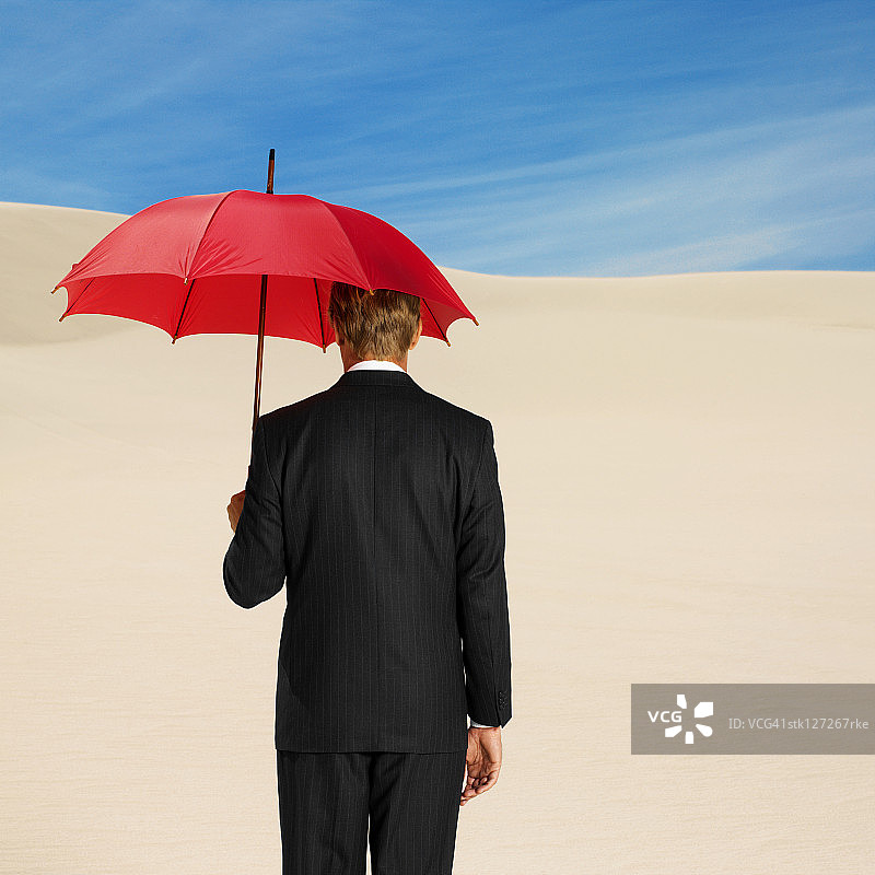 商人撑着伞在沙漠里，后视镜图片素材