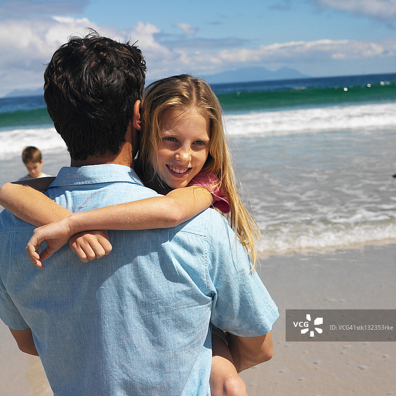 父亲和女儿在海滩上拥抱的特写图片素材