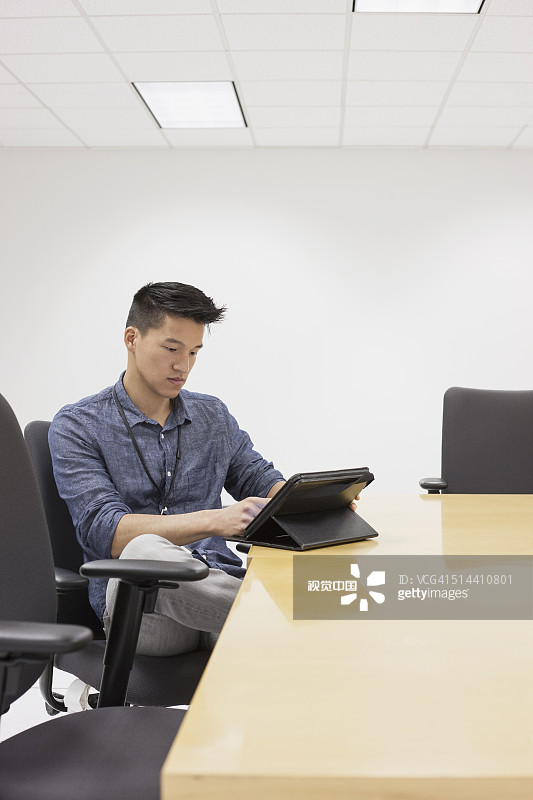 中国商人在会议室里使用平板电脑图片素材